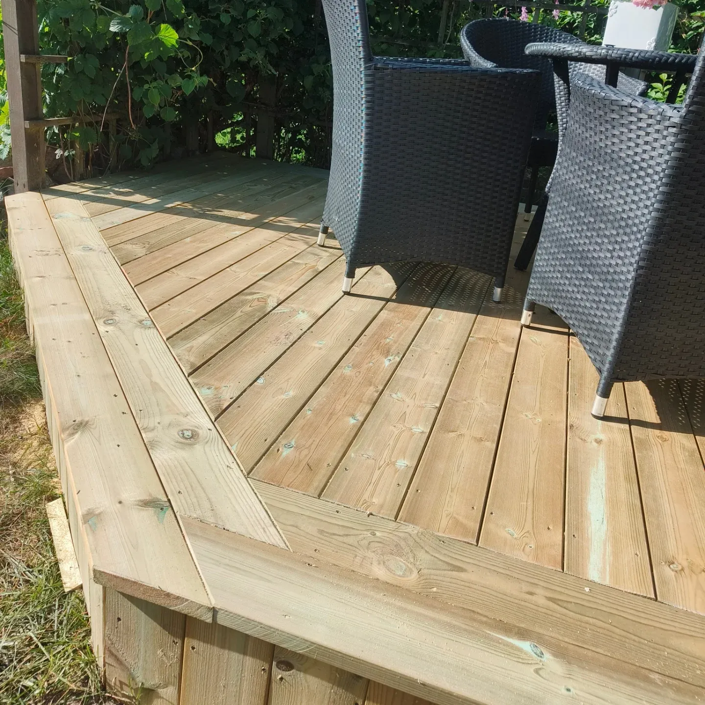 Detalj av altangolv med gerade hörn och sittmöbler